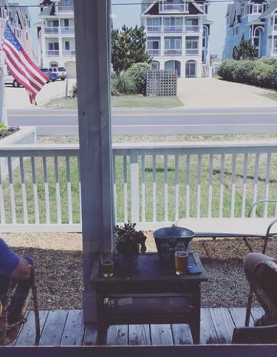 Two people on the porch enjoying a beer at Jack Brown's Kill Devil Hills, NC.